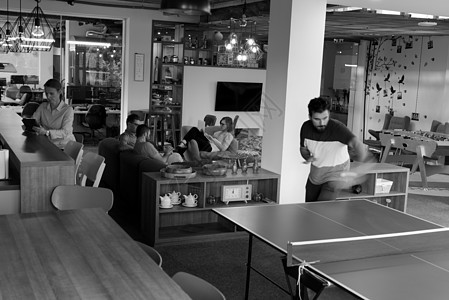 在有创意的办公空间打乒乓网球桌子男人优胜者欢呼休息办公室女性男性商务同事图片