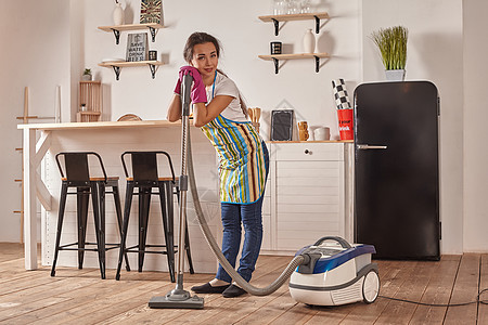 年轻妇女在家中厨房用吸尘器清洁工做清洁和杂务 内地细心整洁电子产品女性女佣身份主妇女孩工具家庭服务地毯图片