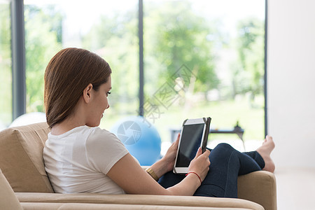 妇女用平板电脑坐在沙发上长椅闲暇技术女士白色成人奢华女性女孩快乐美丽的高清图片素材