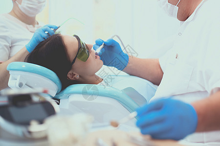 牙医和他的助手进行彻底检查药品访问牙科程序女性男人外科手术矫正病人图片
