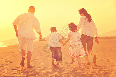 快乐的年轻家庭 在日落时在海滩上玩得开心男生女孩成人假期父母孩子们父亲女儿微笑男性图片