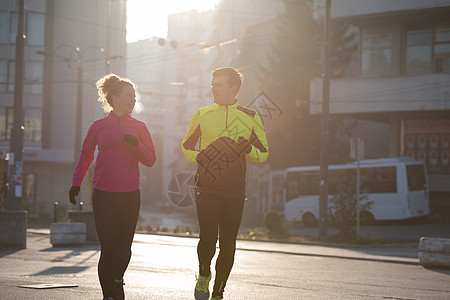 年轻夫妇慢跑男人潮人朋友们娱乐城市慢跑者闲暇运动员太阳跑步图片