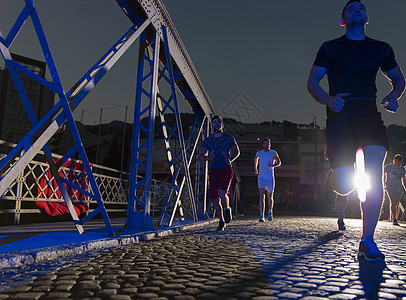 年轻人在桥对面慢跑跑步慢跑者男人城市赛跑者训练团体女士街道活动图片