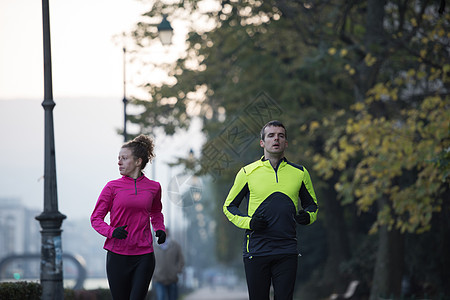 年轻夫妇慢跑卷曲女性训练跑步公园夫妻女孩赛跑者男性朋友们图片