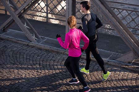 年轻夫妇慢跑女性男性朋友们女士夫妻慢跑者卷曲男人太阳赛跑者图片