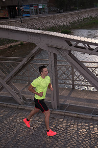 一个年轻人在城里慢跑娱乐活力运动健康赛跑者城市运动员跑步活动男人图片