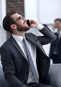 在现代建筑里通过电话交谈的迷人的生意人经理男人顾问笔记本职场手机管理人员微笑商业商务图片