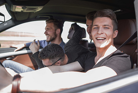 一群男孩骑着车 直接看着汽车安全幸福男性车辆微笑司机男人旅行车轮骑术图片