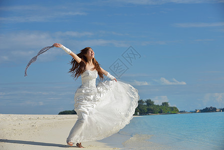 海滩上的亚洲新娘帽子裙子海洋成人自由黑发天空婚姻妻子蜜月图片