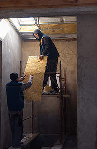 安装热绝缘层的屋顶男子岩棉羊毛玻璃纤维木头建设者程序面板男人岩石建筑图片