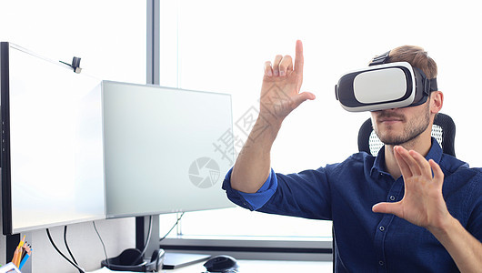 年轻人在现代室内设计工作室里 戴着虚拟现实眼镜的年轻男士图片