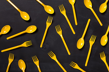 黑色背景上塑料叉的顶部视图厨房蓝色勺子阴影潮人菜肴桌子创造力红色黄色图片