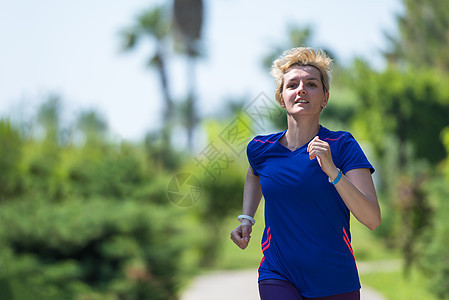 参加马拉松比赛的年轻女青年选手培训耐力运动员慢跑者跑步棕榈赛跑者阳光热带运动女士图片