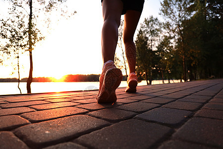 跑步者脚踏在路上 紧贴鞋底 日落或日出时户外女士慢跑女孩赛跑者耀斑活力闲暇健康速度活动图片