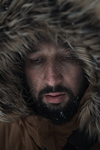 身着温暖的毛皮夹克 在暴风雨中的冬季男子胡子冒险天气兜帽男人旅游旅行高山冷冻雪花图片
