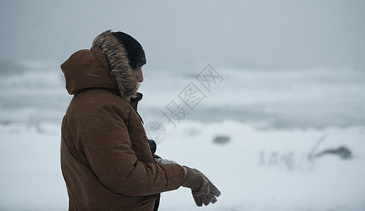 身着温暖的毛皮夹克 在暴风雨中的冬季男子高山天气冷冻帽子男人旅游游客冒险雪花旅行图片