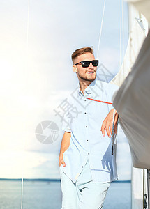 在度假帆船游艇上快乐的放松男人 站在甲板上旅行商业海浪男性运输奢华女性太阳镜巡航速度图片
