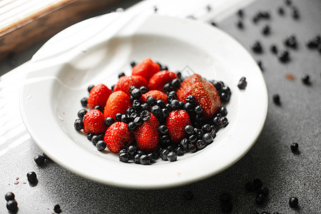 多汁的新鲜鲜熟红草莓和黑莓 躺在阳光照耀下桌子上的白陶瓷板上排毒收成制品早餐饮食产品盘子水果陶瓷浆果图片