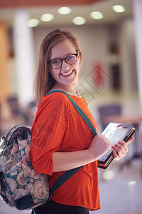 使用平板电脑的女学生女孩互联网笔记本技术女性大学工作屏幕教育背包图片