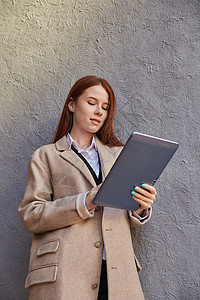 穿着外套的年轻白人时尚女孩使用平板电脑 阅读新闻 社交媒体工具头发闲暇季节微笑药片女性冲浪长发褐色图片