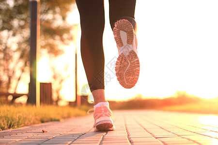 跑步者脚踏在路上 紧贴鞋底 日落或日出时户外训练马拉松身体耀斑活动闲暇慢跑者慢跑耐力运动员图片