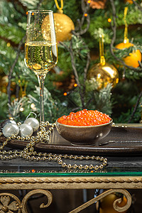 陶瓷碗中的红鱼子酱 银珠珠和珍珠 以及银盘上的香槟杯 圣诞和图片