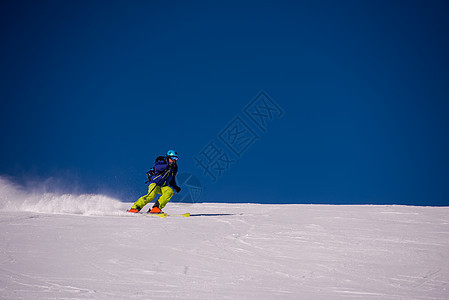 滑雪者在下坡时玩得开心晴天山腰季节粉末男人高山娱乐滑雪天空夹克图片