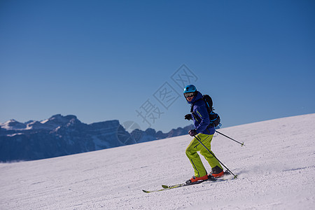 滑雪者在下坡时玩得开心行动粉末速度晴天乐趣娱乐滑雪夹克天空冻结图片