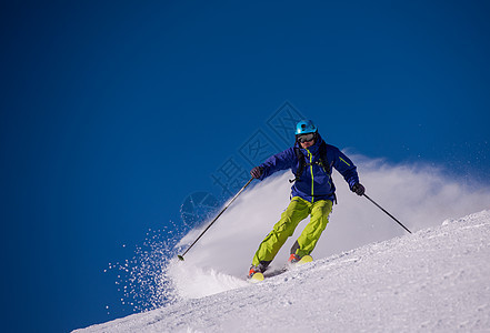 滑雪者在下坡时玩得开心山腰男人滑雪季节空气晴天衣服竞争粉末娱乐图片
