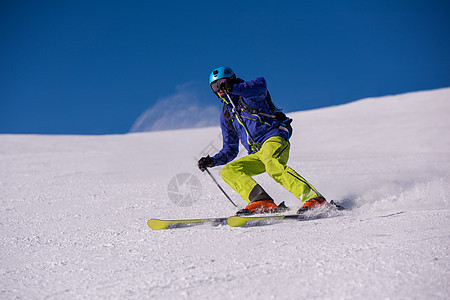 滑雪者在下坡时玩得开心天空冻结粉末衣服季节空气竞争山腰速度乐趣图片