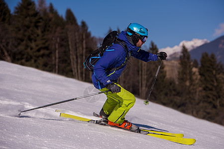 滑雪者在下坡时玩得开心竞赛娱乐季节乐趣冻结山腰运动滑雪衣服天空图片