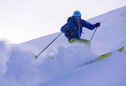 滑雪者在下坡时玩得开心高山衣服乐趣旅行男人滑雪空气速度竞争晴天图片