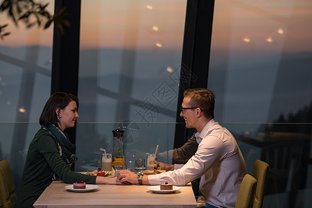 一对情侣在餐厅的浪漫晚餐桌子用餐女朋友男性周年女士生日女孩玻璃男朋友图片