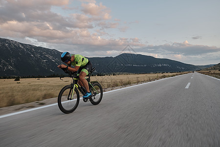 骑自行车的三重运动员耀斑娱乐赛车手钢铁侠头盔速度男性旅行训练运动图片