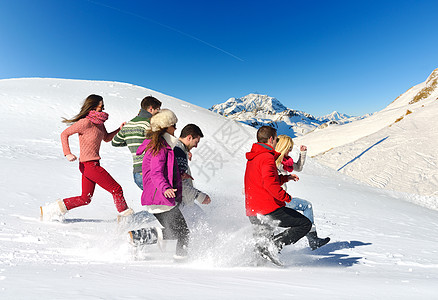 朋友在冬天的清雪上玩得开心团队喜悦太阳天空娱乐朋友们友谊乐趣闲暇旅行图片
