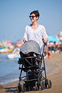 母亲在海滩上行走 推婴儿车女孩孩子成人女士女儿公园母性运输城市女性图片