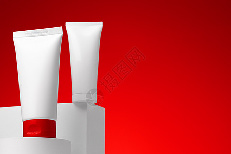 红色泼墨背景红底的白化妆品皮肤护肤容器奶油润肤卫生背景管子红色空白凝胶产品护理背景