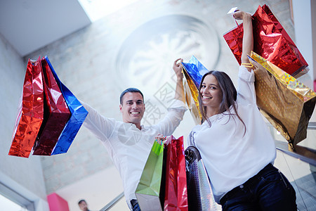 购物中快乐的年轻夫妇购物中心裙子衣服乐趣男性男人楼梯女士店铺妻子图片