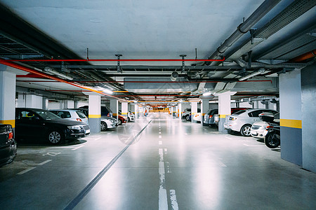 许多汽车停在地下停车场内 照明灯光照亮图片