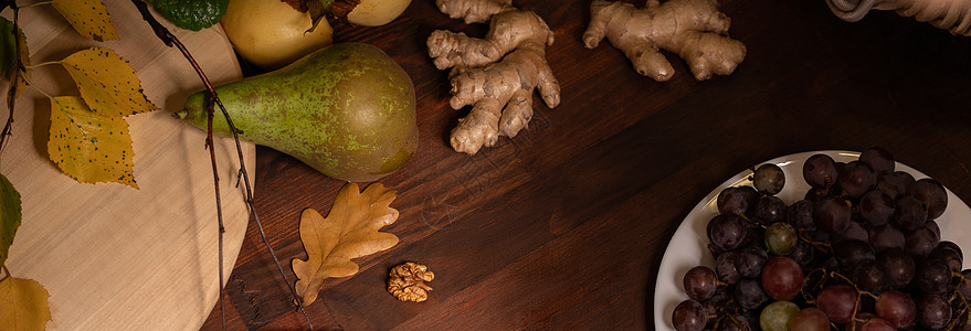 全景横幅 特写一张木桌上的水果 葡萄 姜根的顶视图 葡萄酒小吃套装 木板上精选的奶酪 葡萄 梨和核桃图片
