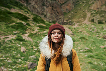 穿着黄色外套的女人 背着背包 在山上山区旅行冒险孤独成人天气活动勘探远足者学生运动女士自由图片