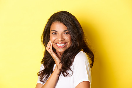 美丽的非洲裔美国女性的形象 微笑的轻浮和感人的脸 广告美容产品 站在黄色背景下发型促销多样性情感员工黑发女孩成人女士工作图片