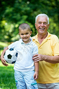 爷爷和孩子在公园玩得开心喜悦足球微笑童年父母祖父家庭祖父母自行车男生图片