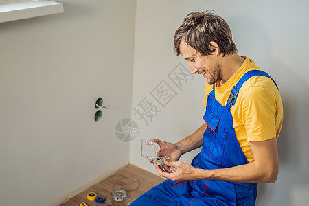 主电工在房屋内安装插座装置接线维修工具电气工作男性力量房子工人螺丝刀图片