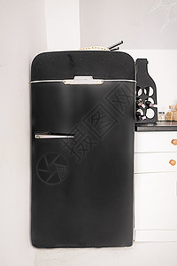 白色厨房的小型黑冷冻器 白背景上的旧式黑色壁炉 特写( Kitchen)图片