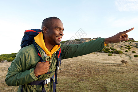 African 美国男子徒步旅行 背着背包 指向方向图片