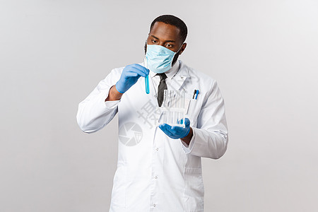 Covid19 冠状病毒患者治疗和实验室概念 戴乳胶手套和医用面罩的专注而细心的非洲裔美国医生 认真对待试管 发明治疗方法 疫苗图片