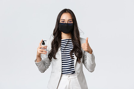 商业 金融和就业 covid19 预防病毒和社会疏远概念 戴着面罩的微笑女商务人士展示洗手液和竖起大拇指 要求使用它口罩疾病员工图片