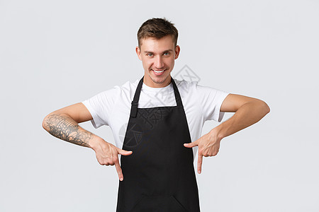 小企业主 咖啡店和员工的概念 自信的金发帅哥在咖啡馆工作 餐厅服务员指着手指微笑 提供保证 推荐地方享受饮品图片