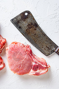 用于烧烤 烘烤或煎炸的有机生生猪肉排 Fith屠宰刀头背负者纹白色背景图片